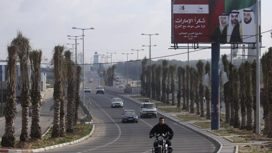 A Palestinian man rides his motorcycle past a billboard with pictures depicting UAE President Sheikh Khalifa bin Zayed al-Nahayan (R), Abu Dhabi Crown Prince Sheikh Mohammed bin Zayed (C) and UAE Deputy Prime Minister Sheikh Mansour bin Zayed al-Nahyan in Gaza City March 15, 2015. The billboard reads, "Thanks Emirates. Gaza is on a date for celebration. Mass wedding project."
REUTERS/Ibraheem Abu Mustafa (GAZA - Tags: SOCIETY POLITICS) - RTR4TED7