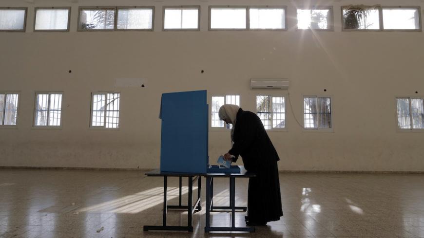 An Israeli Arab stands behind a voting booth before casting her ballot at a polling station in the northern town of Umm el-Fahm March 17, 2015. Millions of Israelis turned out to vote on Tuesday in a tightly-fought election, with Prime Minister Benjamin Netanyahu facing an uphill battle to defeat a strong campaign by the centre-left opposition to deny him a fourth term in office. In a possible sign of edginess, Netanyahu took to Facebook to denounce what he said was an effort by left-wing non-profit groups