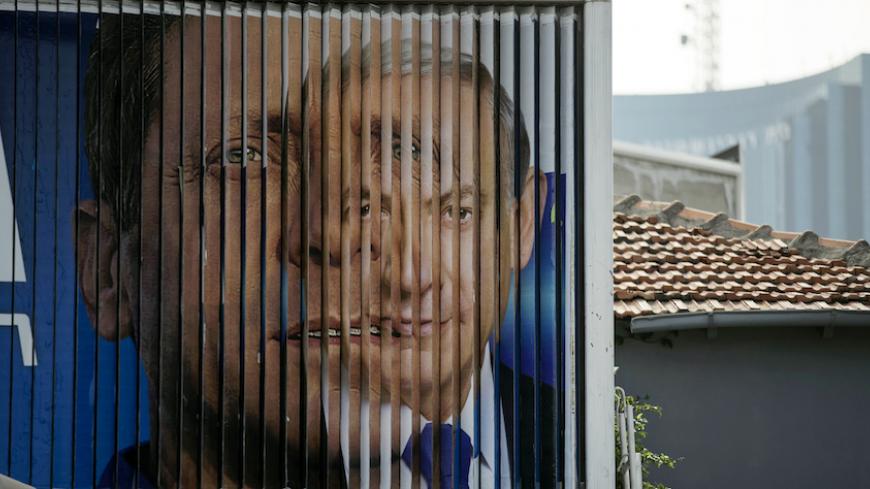 Israel's Prime Minister Benjamin Netanyahu (R) and Isaac Herzog, Co-leader of the centre-left Zionist Union, are pictured together as campaign billboards rotate in Tel Aviv, March 9, 2015. Israelis will vote in a parliamentary election on March 17, choosing among party lists of candidates to serve in the 120-seat Knesset. Currently, polls show Netanyahu's Likud party and the centre-left Zionist Union opposition running neck-and-neck, with each predicted to win around 24 seats in the Knesset. 
REUTERS/Baz Ra