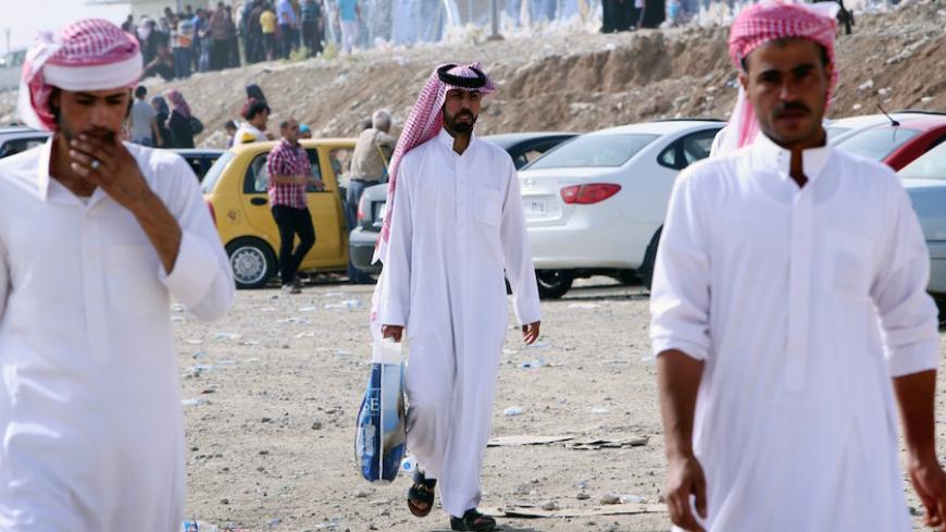 Tribesmen walk at a temporary camp set up to shelter Iraqis fleeing violence in Iraq's northern Nineveh province on June 12, 2014, in Aski kalak, 40 kms West of Arbil, in the autonomous Kurdistan region. Thousands of people who fled Iraq's second city of Mosul after it was overrun by jihadists wait in the blistering heat, hoping to enter the safety of the nearby Kurdish region and furious at Baghdad's failure to help them.  many as half a million people are thought to have fled Mosul, which was captured by 