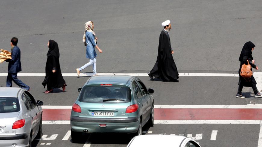 Iranians cross a road in Tehran on April 1, 2015. AFP PHOTO / ATTA KENARE (Photo credit should read ATTA KENARE/AFP/Getty Images)