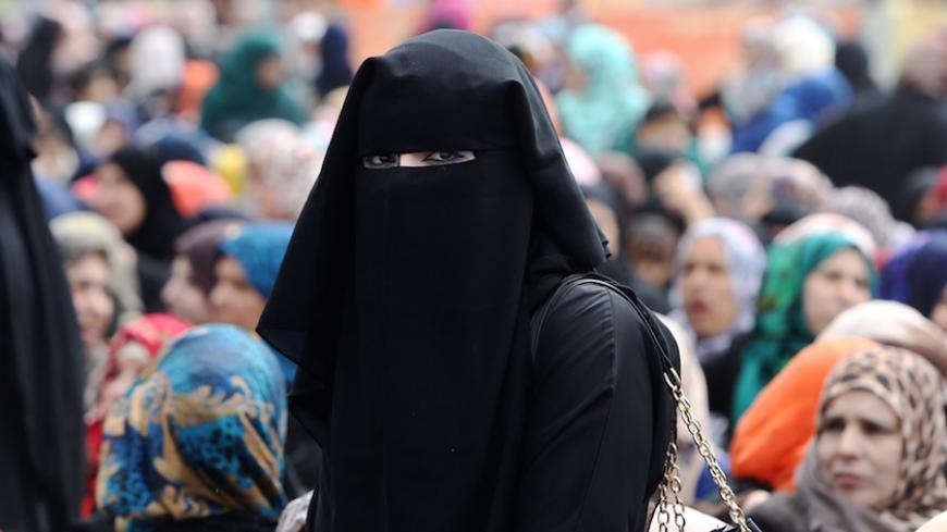 A Palestinian woman looks on during a mass wedding ceremony in Gaza City, on April 11, 2015. Nearly 200 Palestinian couples were married in a ceremony funded by an Emirati governmental organisation. AFP PHOTO / MAHMUD HAMS        (Photo credit should read MAHMUD HAMS/AFP/Getty Images)