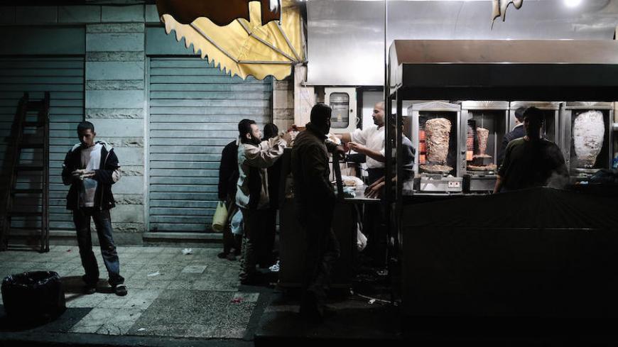 Palestinians buy sandwiches from a restaurant in Gaza City on January 18, 2009. Taking advantage of a ceasefire, restaurants in the Gaza Strip re-opened their doors to customers at night for the first time since the beginning of Israel's offensive. Palestinian militants announced a one-week ceasefire today after Israel called a unilateral halt to the massive offensive on Gaza that has killed 1,300 people since beginning on December 27. AFP PHOTO OLIVIER LABAN-MATTEI (Photo credit should read OLIVIER LABAN-M