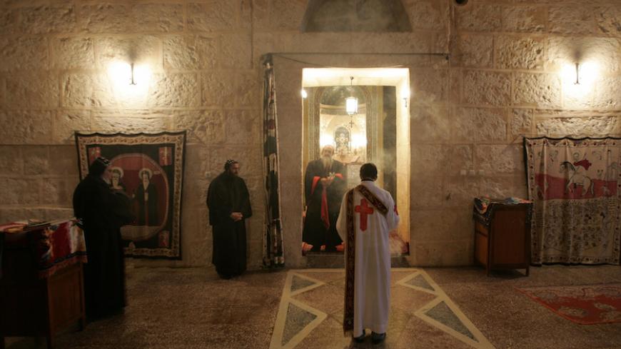Syriac Christian monks attend a service at the ancient monastery of Mor Gabriel, 15 km (9 miles) away from the town of Midyat, in Mardin province of southeast Turkey January 13, 2009. Tucked amid rugged hills where mosques and minarets are silhouetted in the distance, the fifth century Mor Gabriel monastery stands out as a relic of another era when hundreds of thousands of Syriac Christians lived and worshipped in Turkey. But a land dispute between Mor Gabriel and neighbouring villages is threatening the mo