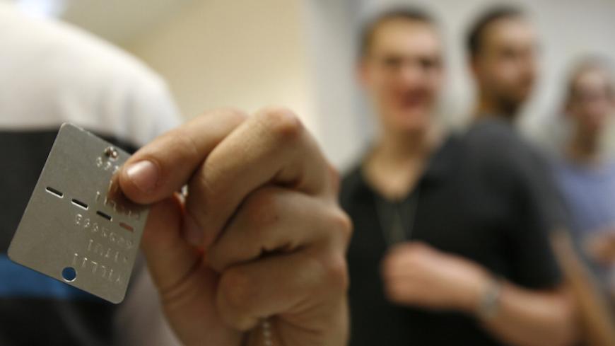 A conscript displays his identifying dog tag at the Tel Hashomer Israel Defence Forces (IDF) Recruitment Center near Tel Aviv March 14, 2010. About 500 Israeli men were drafted into the armoured corps on Sunday. Under Israeli law, Jewish men at the age of 18 are required to serve in the army for three years and women for two. REUTERS/Gil Cohen Magen (ISRAEL - Tags: MILITARY SOCIETY) - RTR2BN27