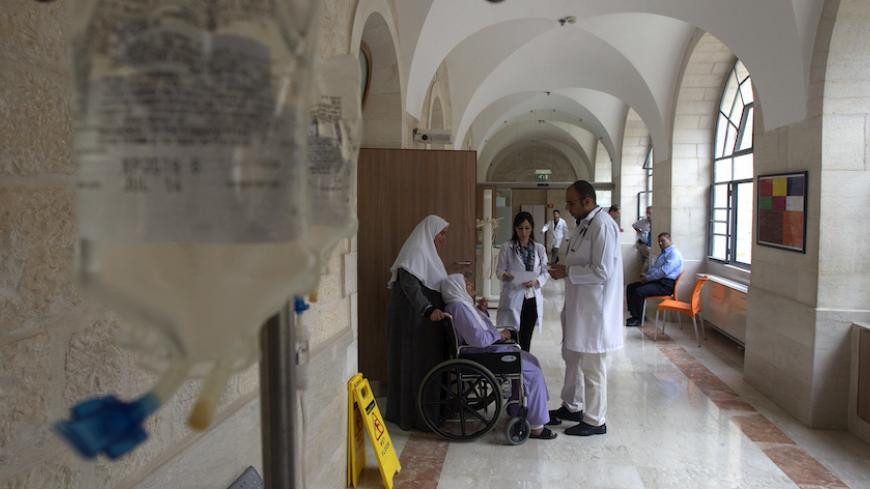 Doctors speak to a Palestinian patient at Augusta Victoria Hospital in East Jerusalem November 6, 2012. Six hospitals in East Jerusalem face a financial crisis because the aid-dependent Palestinian Authority has been unable to meet payments for their services, jeopardizing the healthcare of thousands of West Bank patients. REUTERS/Baz Ratner (JERUSALEM - Tags: HEALTH POLITICS BUSINESS) - RTR3A2BZ