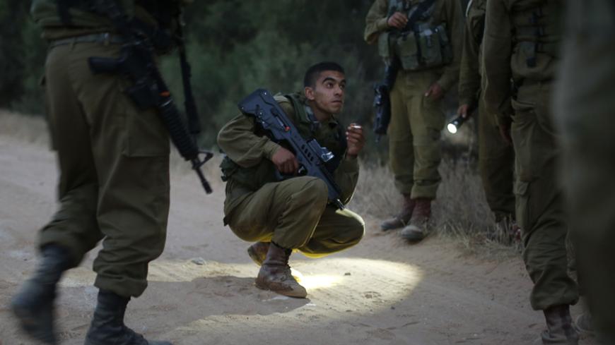 Bedouin Arab Israeli Defense Force soldiers take part in a tracking drill near Tze'elim in southern Israel June 9, 2014. In addition to hi-tech surveillance and intelligence capabilities, Israel relies on the Bedouin volunteers to secure its border regions against "terrorists, illegal immigrants and smugglers," according to the IDF spokesperson. Traditionally nomadic desert people, the Bedouin, who are Muslim, have passed down tracking skills across generations. Picture taken June 9, 2014. REUTERS/Finbarr O