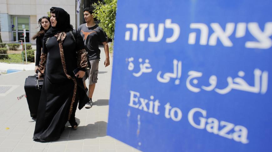 Palestinians walk out of Israel's Erez Crossing after leaving Gaza July 13, 2014. According to a spokesperson for Israel's Coordination of Government Activities in the Territories (COGAT), about 850 Palestinians with dual citizenship left Gaza on Sunday at the request of their foreign embassies. Israeli naval commandos clashed with Hamas militants in a raid on the coast of the Gaza Strip on Sunday, in what appeared to be the first ground assault of a six-day Israeli offensive on the territory aimed at stopp