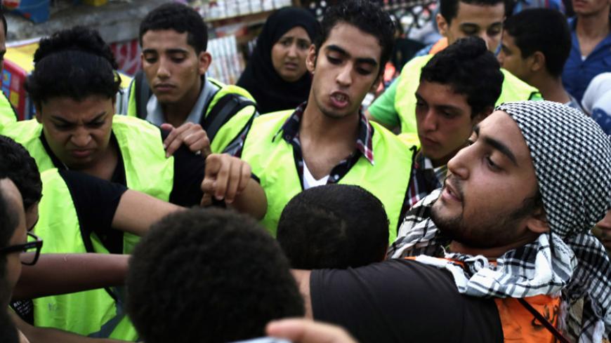 Volunteers from an anti-harassment group called "Harassing the Harasser" detain a young man, after a girl claimed that he was sexually harassing her, during Eid al-Fitr celebrations in central Cairo July 28, 2014. Police and volunteers of anti-harassment groups have been more active since last month's incident of a woman who was sexually assaulted by a mob during celebrations marking the inauguration of President Abdel Fattah al-Sisi, according to local authorities. REUTERS/Asmaa Waguih (EGYPT - Tags: CI