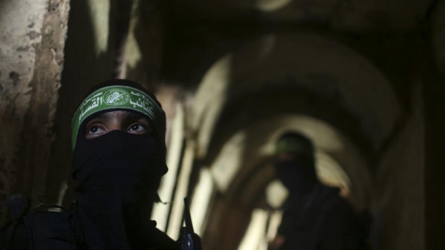 Palestinian fighters from the Izz el-Deen al-Qassam Brigades, the armed wing of the Hamas movement, stand inside an underground tunnel in Gaza August 18, 2014. A rare tour that Hamas granted to a Reuters reporter, photographer and cameraman appeared to be an attempt to dispute Israel's claim that it had demolished all of the Islamist group's border infiltration tunnels in the Gaza war. Picture taken August 18, 2014. To match Exclusive MIDEAST-GAZA/TUNNELS             REUTERS/Mohammed Salem (GAZA - Tags: POL