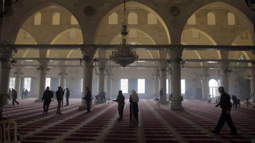 Palestinians clean the Al Aqsa mosque after clashes with Israeli police on the compound known to Muslims as Noble Sanctuary and to Jews as Temple Mount in Jerusalem's Old City November 5, 2014. Israeli security forces entered a Jerusalem holy compound and clashed with Palestinian stone throwers on Wednesday, officials said. Daily clashes between Israeli security forces and Palestinians in the streets of East Jerusalem and the Old City compound have stoked fears of a new Palestinian Intifada, or uprising. RE