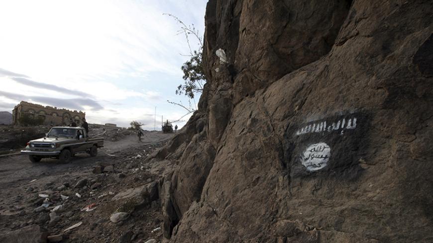 Shi'ite Houthi rebels drive a patrol truck past a Ansar al-Sharia flag painted on the side of a hill, along a road in Almnash, the main stronghold of Ansar al-Sharia, in Rada November 22, 2014. Shi'ite Houthi fighters recently managed to enter the area, which had long been the main stronghold of Ansar al-Sharia, the local wing of Al Qaeda in the Arabian Peninsula (AQAP). Picture taken November 22, 2014. REUTERS/Mohamed al-Sayaghi (YEMEN - Tags: CIVIL UNREST TPX IMAGES OF THE DAY CONFLICT) - RTR4F880