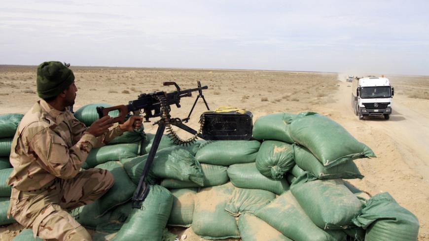 A member of the Iraqi security forces takes up position with his weapon in the desert between Anbar and Kerbala, February 24, 2015. Picture taken February 24, 2015. REUTERS/Mushtaq Muhammed (IRAQ - Tags - Tags: CIVIL UNREST CONFLICT POLITICS MILITARY) - RTR4R3AU
