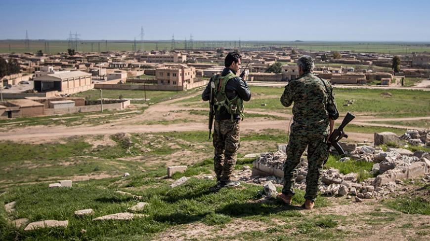 Kurdish People's Protection Units (YPG) fighters stand with their weapons in Tel Hamis in Hasaka countryside March 1, 2015. Kurdish forces dealt a blow to Islamic State by capturing Tel Hamis, an important town, on Friday in the latest stage of a powerful offensive in northeast Syria, a Kurdish militia spokesman said. The capture of Tel Hamis was announced by the Kurdish YPG militia and confirmed by the Syrian Observatory for Human Rights, which monitors the country's civil war. REUTERS/Rodi Said (SYRIA - T