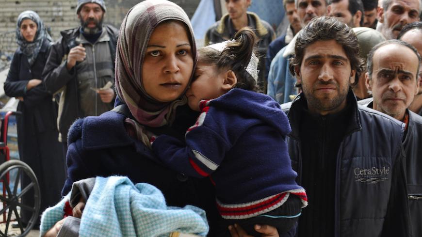 Residents queue up to receive humanitarian aid at the Palestinian refugee camp of Yarmouk, in Damascus March 11, 2015. The Palestinian Yarmouk refugee camp in Damascus, which is under siege by Syrian government forces fighting rebels, has received its first relief supplies since the beginning of December. The aid was delivered by the United Nations Relief and Works Organization (UNRWA) on March 5, the organisation said in a news release.
REUTERS/Stringer (SYRIA - Tags: POLITICS CIVIL UNREST CONFLICT) - RTR