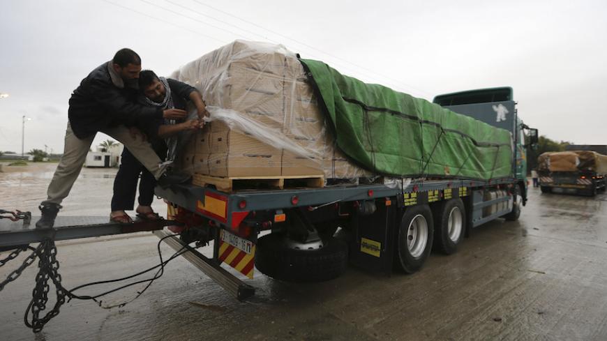 Palestinians cover cartons containing vegetables before exporting them to Israel, at the Kerem Shalom crossing in Rafah in the southern Gaza Strip March 12, 2015. Israel imported its first fruit and vegetables from the Gaza Strip in almost eight years on Thursday, in a partial easing of an economic blockade maintained since the Islamist group Hamas seized control of the Palestinian territory. Twenty-seven tonnes of tomatoes and five tonnes of eggplants were trucked across the border under an Israeli plan t
