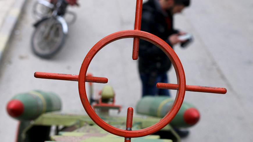 A rebel fighter of al-Jabha al-Shamiya (the Shamiya Front) is seen through the scope of a new locally made cannon named "al-Qannas" (Sniper) before launching it towards forces loyal to Syria's President Bashar al-Assad stationed in Hanano barracks in Aleppo April 8, 2015. The cannon is decorated with two mock rockets. REUTERS/Abdalrhman Ismail - RTR4WJOI