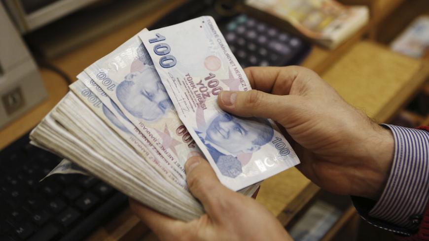 A money changer counts Turkish lira bills at a currency exchange office in central Istanbul January 29, 2014. Turkish Finance Minister Mehmet Simsek played down the impact on growth of a sharp hike in interest rates on Wednesday, saying the economy would have suffered greater damage from a loss of faith in the central bank. The bank raised all its key interest rates in dramatic fashion at an emergency policy meeting late on Tuesday, ignoring opposition from Prime Minister Tayyip Erdogan as it battles to def