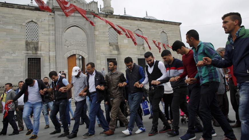 Supporters of pro-Kurdish People's Democratic Party (HDP) dance near an election campaign point in Istanbul, Turkey, May 28, 2015. Turkey's Pro-Kurdish People's Democratic Party (HDP) said on Wednesday June elections would lack legitimacy if a threshold for parliamentary representation deprived it of representation, but it would remain a partner in peace talks with militants. The fate of the HDP, which hopes to cross the 10 percent national vote threshold to enter parliament on June 7, will be critical not 