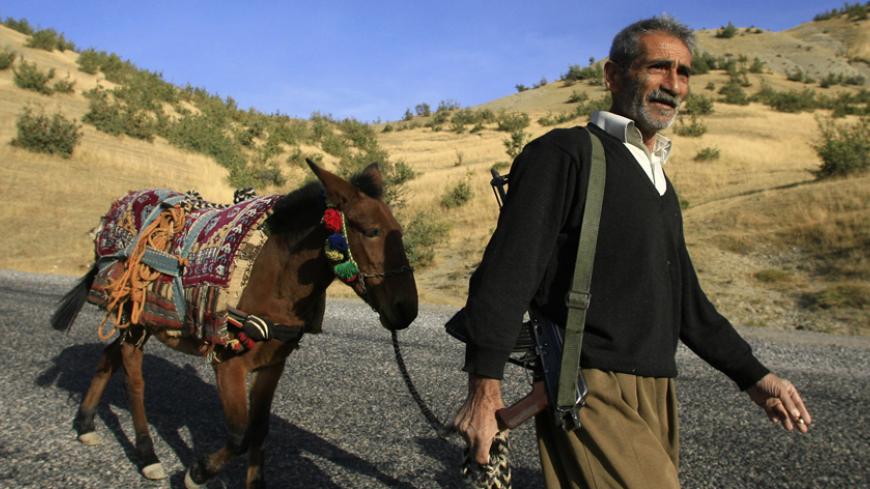 A Kurdish village guard patrols a road in the southeastern Turkish province of Sirnak in this October 23, 2007 file photo. Ankara has amassed 100,000 troops on its border with Iraq and threatened a cross-border offensive to crack down on rebels of the outlawed Kurdistan Workers' Party (PKK) based in mainly Kurdish northern Iraq. To match feature TURKEY-IRAQ/GUARDS  REUTERS/Osman Orsal   (TURKEY) - RTXBBD