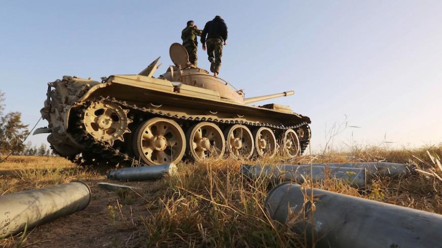 Fighters from the Fajr Libya (Libya Dawn) militia stand on a tank during clashes with forces loyal to Libya's internationally recognised government, southwest of Sabratha, in the vicinity the Wetia military air base  some 87 kilometres west of the capital Tripoli, on April 28, 2015. AFP PHOTO / MAHMUD TURKIA        (Photo credit should read MAHMUD TURKIA/AFP/Getty Images)