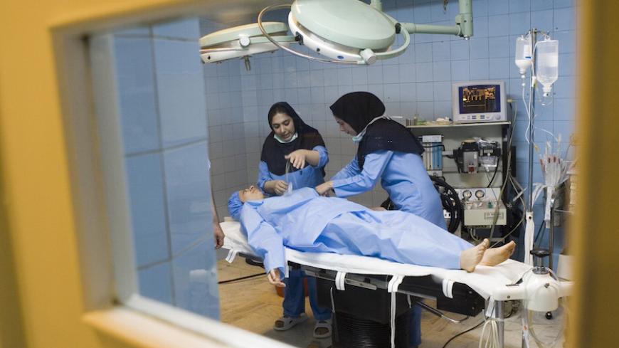 Nurses prepare Iranian woman Arezoo Abassi in the operating room as she gets ready for a surgery on her nose at a surgical clinic in Tehran May 29, 2007. REUTERS/Caren Firouz (IRAN) - RTR1Q8AF
