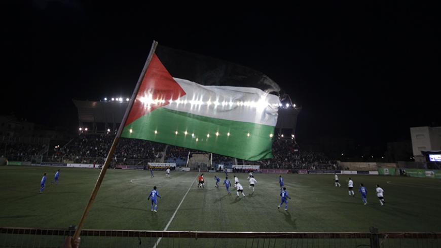 A Palestinian national flag is seen during the Olympic games qualifying match between Palestinian and Thai national soccer teams at a stadium in the West Bank town of A-Ram near Jerusalem March 9, 2011. The match is the first official international fixture to be hosted on Palestinian home soil. REUTERS/Ammar Awad (WEST BANK - Tags: SPORT SOCCER) - RTR2JOA8
