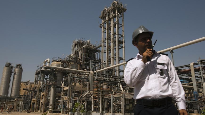 A security personnel stands in front of the Mahshahr petrochemical plant in Khuzestan province,1032 km (641 miles) southwest of Tehran, September 28, 2011. REUTERS/Raheb Homavandi  (IRAN - Tags: BUSINESS ENERGY INDUSTRIAL) - RTR2RYWC