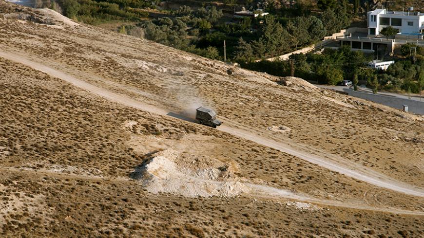 A Lebanese Army vehicle drives down a mountain next to Ras-Baalbek, a Christian village on the outskirts of Arsal, August 30, 2014. Lebanese Christian fighters from three Christian villages that surround Arsal have been training for about three years and guarding their villages for the past year fearing a violent spillover from nearby Arsal, which is controlled by Islamic militias, according to the fighters. Picture taken August 30, 2014. REUTERS/Alia Haju (LEBANON - Tags: POLITICS CIVIL UNREST MILITARY) - 