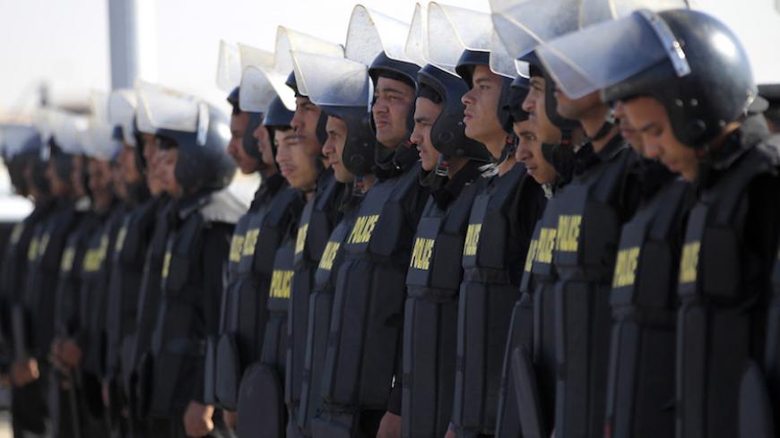 Police and security forces stand guard outside a police academy where the trial of ormer Egyptian President Hosni Mubarak is held on the outskirts of Cairo November 29, 2014. An Egyptian court on Saturday dropped its case against ousted president Hosni Mubarak on charges of ordering the killing of protesters during the 2011 revolt that removed him from power. The court also cleared Mubarak and a former oil minister of graft charges related to gas exports to Israel. REUTERS/Mohamed Abd El Ghany (EGYPT - Tag