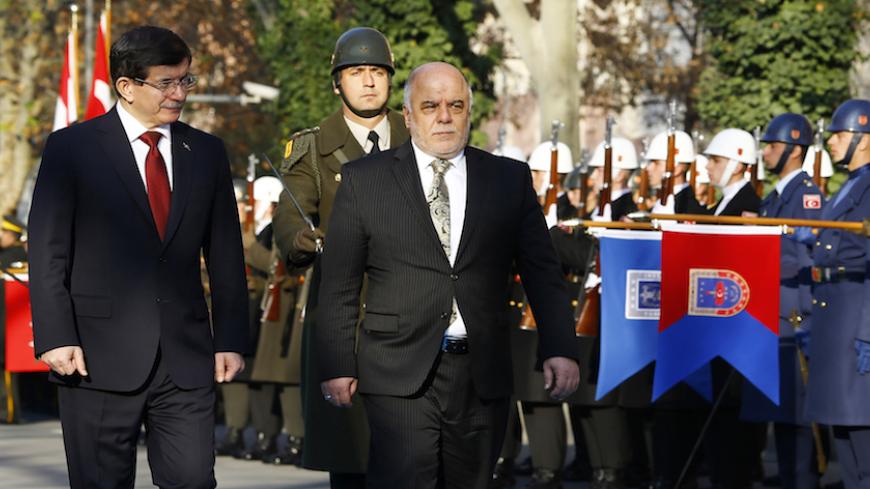 Turkey's Prime Minister Ahmet Davutoglu (L) and Iraqi Prime Minister Haider al-Abadi review a guard of honour during a welcoming ceremony in Ankara December 25, 2014. REUTERS/Umit Bektas (TURKEY - Tags: POLITICS) - RTR4J8KH