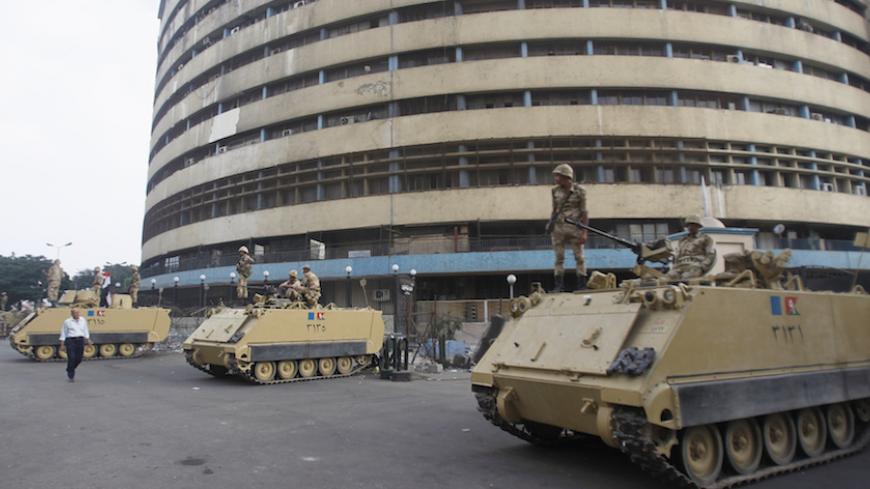 Soldiers stand on an armoured personnel carrier positioned outside the state-run television station in Cairo July 6, 2013. REUTERS/Khaled Abdullah (EGYPT - Tags: POLITICS CIVIL UNREST MILITARY MEDIA) - RTX11E7B