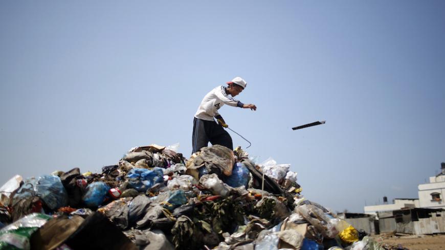 A Palestinian sifts through garbage for salvageable items at a local dump site, in the east of Gaza City September 2, 2013.  REUTERS/Mohammed Salem (GAZA - Tags: ENVIRONMENT SOCIETY) - RTX134M2