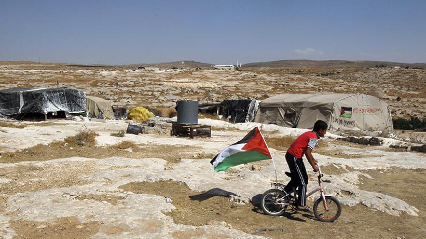 A Palestinian boy rides a bicycle past tents in the West Bank village of Susiya June 24, 2012. Susiya the Israeli settlement enjoys well-watered lawns, humming electricity, and the protection of a mighty state. One rocky hill away, Susiya the Palestinian village is parched and doomed. Picture taken June 24, 2012. To match Feature ISRAEL-PALESTINIANS/DEMOLITION
REUTERS/Baz Ratner (WEST BANK - Tags: POLITICS) - RTR347HR