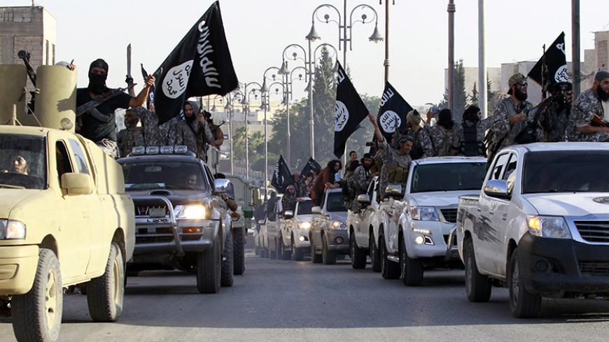 Militant Islamist fighters parade on military vehicles along the streets of northern Raqqa province June 30, 2014. Militant Islamist fighters held a parade in Syria's northern Raqqa province to celebrate their declaration of an Islamic "caliphate" after the group captured territory in neighbouring Iraq, a monitoring service said. The Islamic State, an al Qaeda offshoot previously known as Islamic State in Iraq and the Levant (ISIL), posted pictures online on Sunday of people waving black flags from cars and