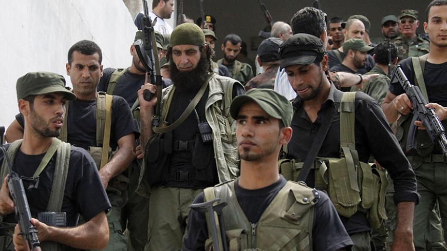 Palestinian gunmen from different factions hold their weapons during the launch of a joint security force that includes all Palestinian factions, to maintain stability at the Ain al-Hilweh Palestinian refugee camp near the port-city of Sidon, southern Lebanon July 8, 2014.
REUTERS/Ali Hashisho (LEBANON - Tags: POLITICS MILITARY) - RTR3XMS5