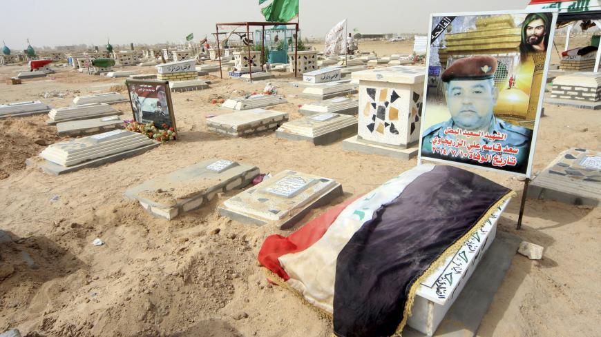 A grave of an Iraqi soldier is seen at a cemetery in Kerbala, southwest of Baghdad, September 30, 2014. With the tide of deaths registered in Kerbala and elsewhere showing no sign of abating, some Shi'ites are starting to complain out loud that the government and army command are incompetent at best, culpable at worst, and covering up the true of extent of battlefield losses. Picture taken September 30, 2014. REUTERS/Mushtaq Muhammed (IRAQ - Tags: CIVIL UNREST POLITICS MILITARY CONFLICT) - RTR4995D