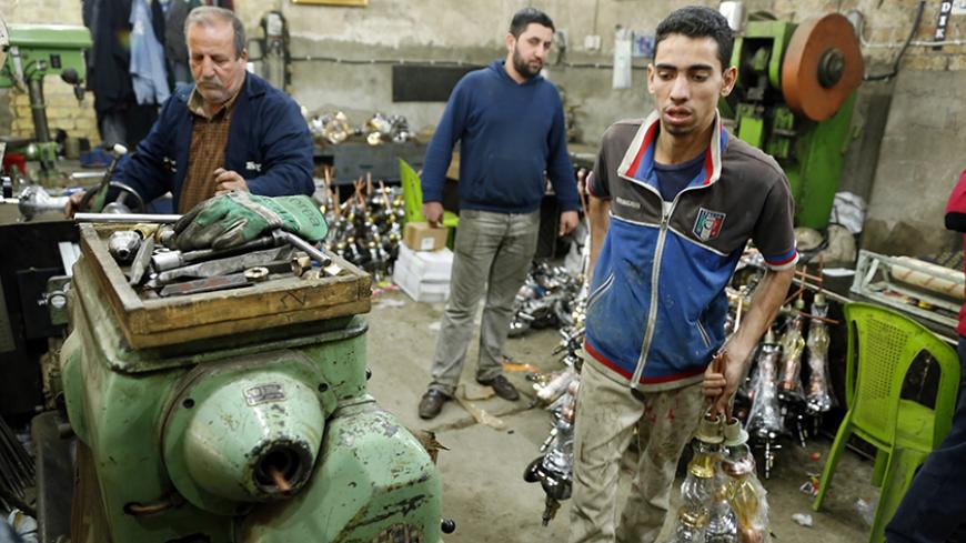 Workers are pictured at a shisha manufacturing factory in Baghdad December 17, 2014. Picture taken December 17, 2014. REUTERS/Thaier Al-Sudani (IRAQ - Tags: SOCIETY BUSINESS) - RTR4JJAB