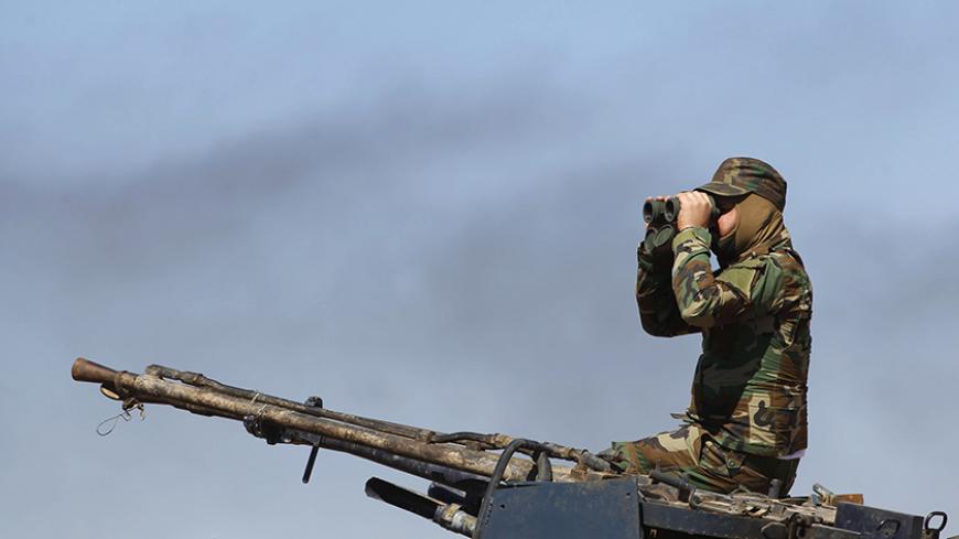 A Shi'ite fighter keeps watch in Al Hadidiya, south of Tikrit, en route to the Islamic State-controlled al-Alam town, where they are preparing to launch an offensive on Saturday, March 6, 2015. Iraqi government forces and Iran-backed militiamen entered a town on the southern outskirts of Saddam Hussein's home city Tikrit on Friday, pressing on with the biggest offensive yet against Islamic State militants that seized the north last year. REUTERS/Thaier Al-Sudani (IRAQ - Tags: POLITICS CIVIL UNREST CONFLICT 
