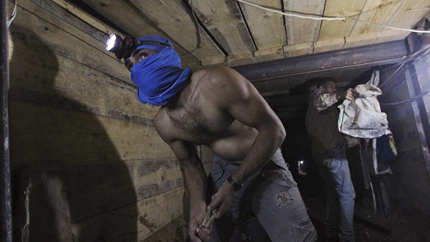 Tunnel workers work inside a smuggling tunnel dug beneath the Gaza-Egypt border in the southern Gaza Strip October 8, 2013. Hamas is struggling to meet its payroll in the Gaza Strip, where income from taxes has been badly hit since neighbouring Egypt started destroying a network of tunnels used to smuggle food, fuel and weapons into the Islamist-run enclave. Picture taken October 8, 2013.
 REUTERS/Ahmed Zakot (GAZA - Tags: POLITICS SOCIETY) - RTX144I5