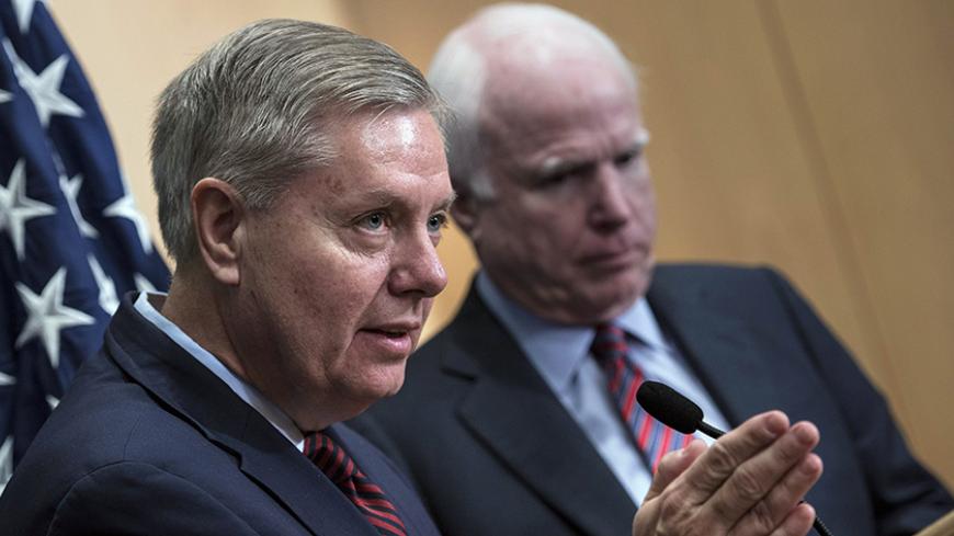 U.S. Senator Lindsey Graham (L) speaks near U.S. Republican Senator John McCain during a news conference at the David Citadel hotel in Jerusalem January 3, 2014. REUTERS/Brendan Smialowski/Pool (JERUSALEM - Tags: POLITICS) - RTX170Z3