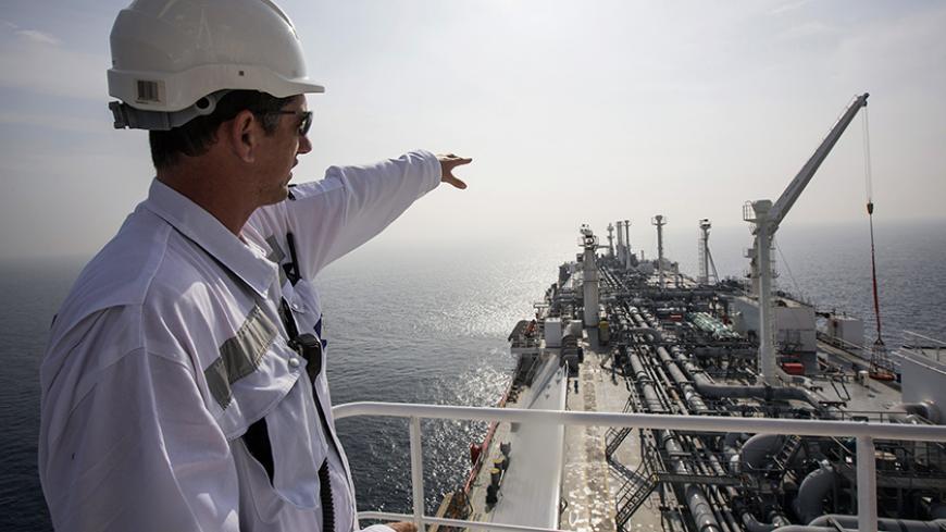 An officer points as he stands on a tanker carrying liquefied natural gas in the Mediterranean, some 10 km (6 miles) from the coastal Israeli city of Hadera January 22, 2014. Permanently anchored in the choppy waters of the eastern Mediterranean, the tanker Excellence is in a constant state of alert, waiting for the emergency phone call that Israel needs fuel. The gas, imported and stored in liquid form on the tanker, can be "regassified" and pumped through a special buoy into an underwater pipeline, provid