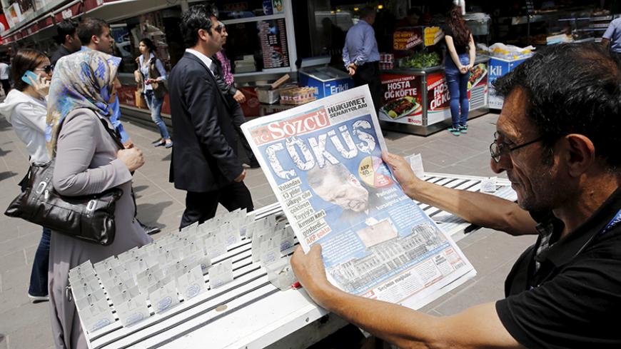 A lottery ticket vendor reads a Turkish newspaper published with an headline reads "downfall" and a portrait of Turkey's President Tayyip Erdogan in Ankara, Turkey, June 8, 2015. Erdogan will meet Prime Minister Ahmet Davutoglu on Monday to discuss Sunday's election results during which the ruling AK Party lost its parliamentary majority. The elections have ushered in the biggest period of political uncertainty in Turkey since AK Party swept to power 13 years ago. REUTERS/Umit Bektas - RTX1FM5M