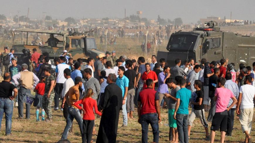 Syrian refugees from Tel Abyad wait on the Turkish-Syrian border after crossing into Turkey near the Akcakale border gate in Sanliurfa province, Turkey, June 14, 2015. Kurdish-led militia backed by U.S.-led air strikes fought Islamic State near a Syrian town at the Turkish border on Sunday, a monitoring group and a Kurdish official said, in an advance that has worried Turkey. Concerned about an expansion of Kurdish sway in Syria, Turkish President Tayyip Erdogan said Kurdish groups were taking over areas ev