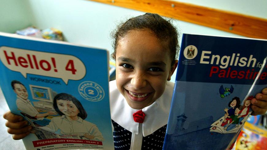 GAZA CITY, GAZA STRIP - SEPTEMBER 1:  A Palestinian girl holds her new books after receiving them from the Dar Al-Arqam Islamic school on the first day of the new school year September 1, 2003 in Gaza City, Gaza Strip. About one million Palestinian students started the new school year in the Gaza Strip and the West Bank. (Photo by Abid Katib/Getty Images)