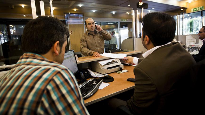 An Iranian customer speaks with a bank clerk at the Export Development Bank of Iran in the capital Tehran on July 27, 2015. Iran's central bank chief said that Iran has assets of $29 billion in overseas banks that could be unlocked under a nuclear deal struck on July 14, far less than reported estimates of over $100 billion. AFP PHOTO / BEHROUZ MEHRI        (Photo credit should read BEHROUZ MEHRI/AFP/Getty Images)