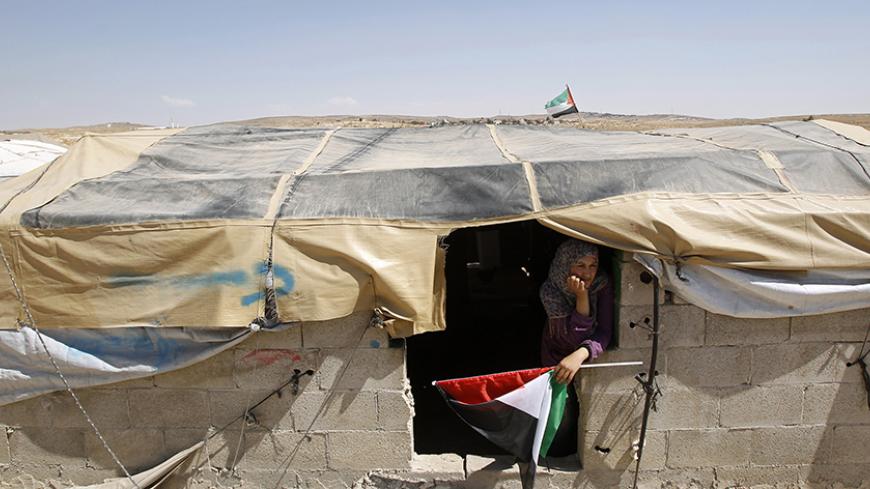 A Palestinian woman holds a Palestinian flag in the West Bank village of Susiya June 24, 2012. Susiya the Israeli settlement enjoys well-watered lawns, humming electricity, and the protection of a mighty state. One rocky hill away, Susiya the Palestinian village is parched and doomed. Picture taken June 24, 2012. To match Feature ISRAEL-PALESTINIANS/DEMOLITION
REUTERS/Baz Ratner (WEST BANK - Tags: POLITICS TPX IMAGES OF THE DAY) - RTR347HZ