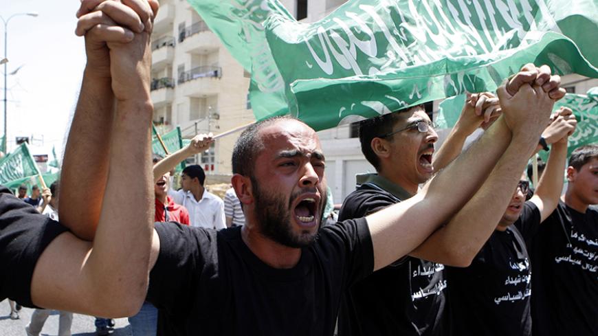 Palestinians take part in a rally calling for the release of Hamas prisoners from the Palestinian authority (PA) jails in the West Bank city of Hebron July 6, 2012. The writing on the T-shirt reads: "We live in dignity or we die martyrs. No for political arrest." REUTERS/ Mussa Qawasma (WEST BANK - Tags: POLITICS CIVIL UNREST) - RTR34NM9