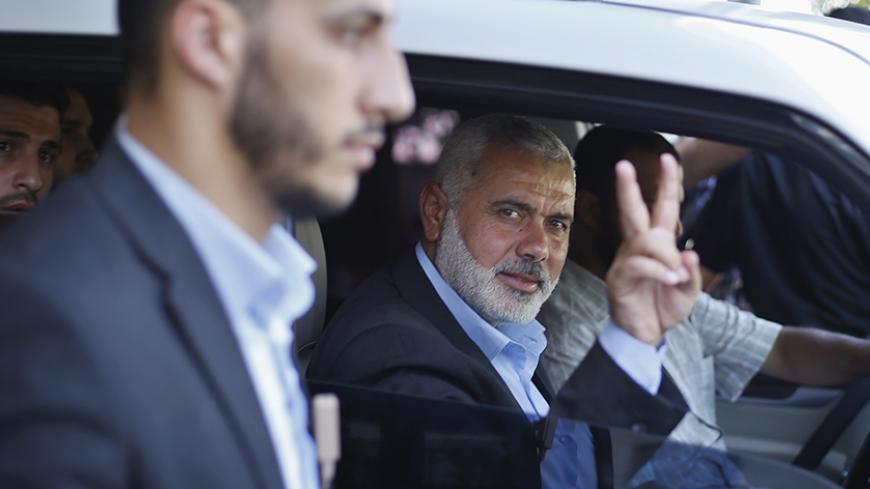 Senior Hamas leader Ismail Haniyeh gestures as leaves his office as a former Hamas government Prime Minister, in Gaza City June 2, 2014. President Mahmoud Abbas swore in a Palestinian unity government on Monday under a reconciliation deal with Hamas Islamists that led Israel to freeze U.S.-brokered peace talks with the Western-backed leader. REUTERS/Suhaib Salem (GAZA - Tags: POLITICS) - RTR3RTYV