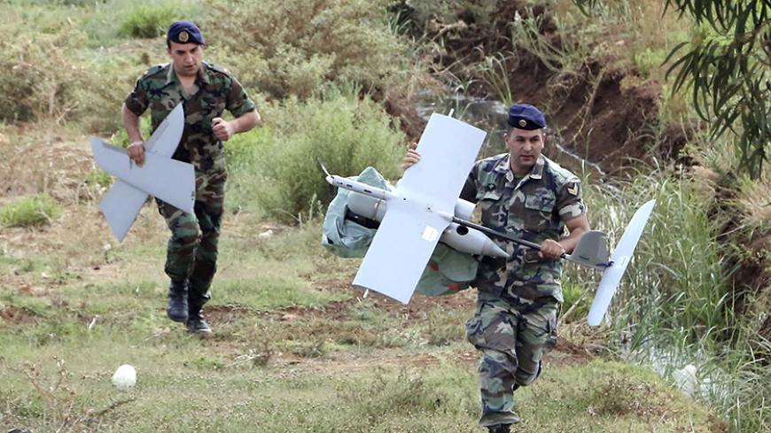 Lebanese Army soldiers carry parts of an Israeli drone in the Marjeyoun countryside, south Lebanon September 20, 2014. The Lebanese Army found the MK drone that fell in the Marjeyoun countryside near the Lebanese-Israeli border, the National News Agency (NNA) reported. The Israel Defence Forces confirmed that the unmanned aerial vehicle was from Israel, according to Israeli media. REUTERS/Karamallha Daher (LEBANON - Tags: POLITICS MILITARY TPX IMAGES OF THE DAY) - RTR4711K